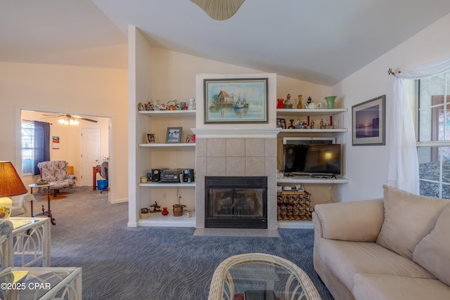 living room featuring a tiled fireplace, lofted ceiling, and carpet flooring