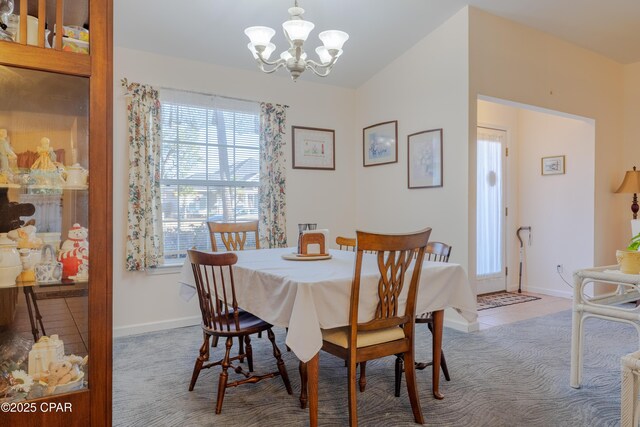 tiled dining area featuring vaulted ceiling and an inviting chandelier