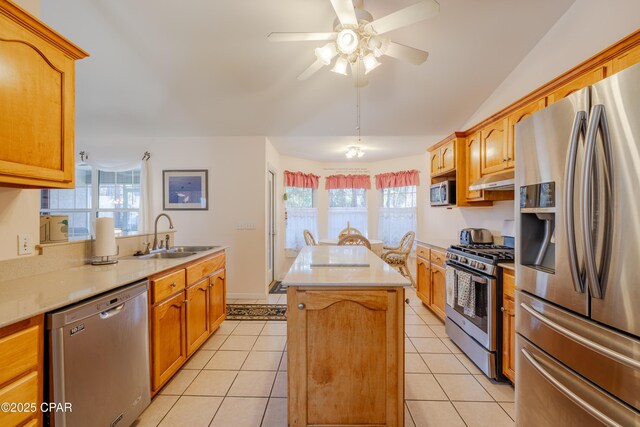 kitchen with sink, light tile patterned floors, a kitchen island with sink, stainless steel appliances, and vaulted ceiling