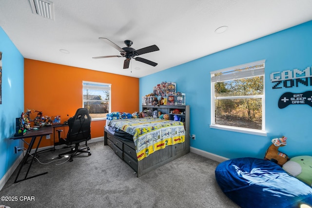 carpeted bedroom with ceiling fan and multiple windows