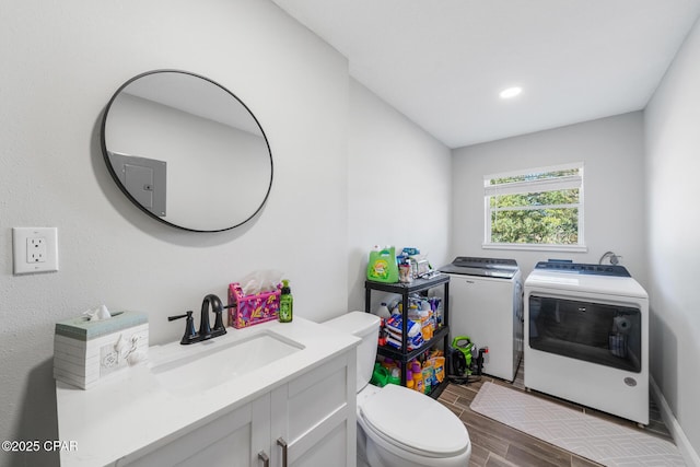 bathroom featuring vanity, toilet, and washer and clothes dryer