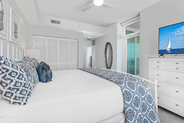 carpeted bedroom featuring ceiling fan and a closet