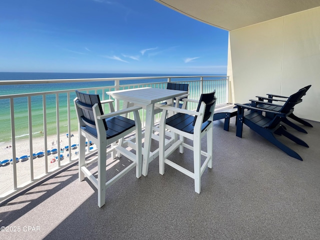 balcony featuring a view of the beach and a water view