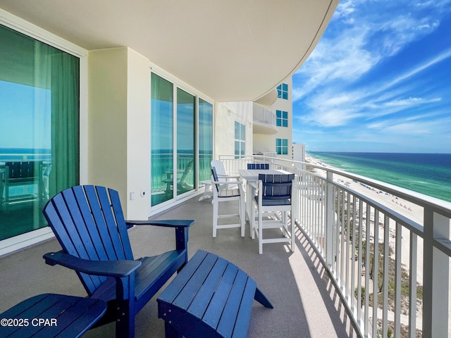 balcony featuring a beach view and a water view