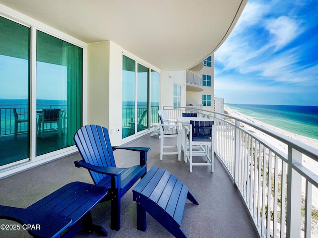 balcony featuring a view of the beach and a water view