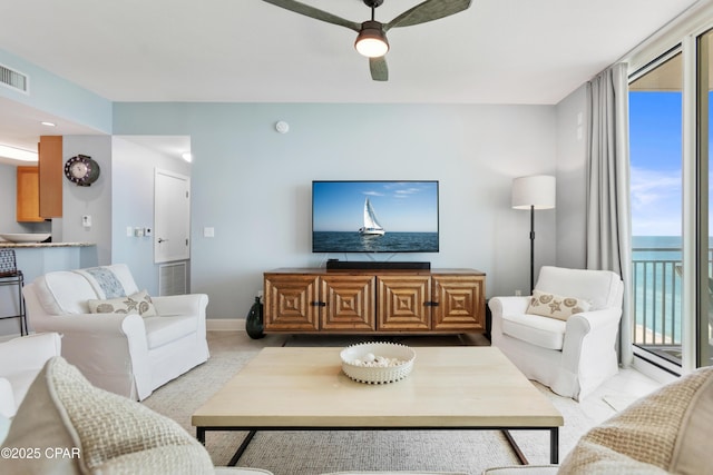 living room with floor to ceiling windows and ceiling fan