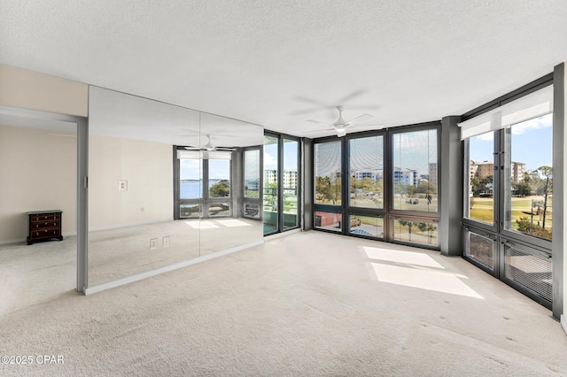 unfurnished sunroom featuring a ceiling fan