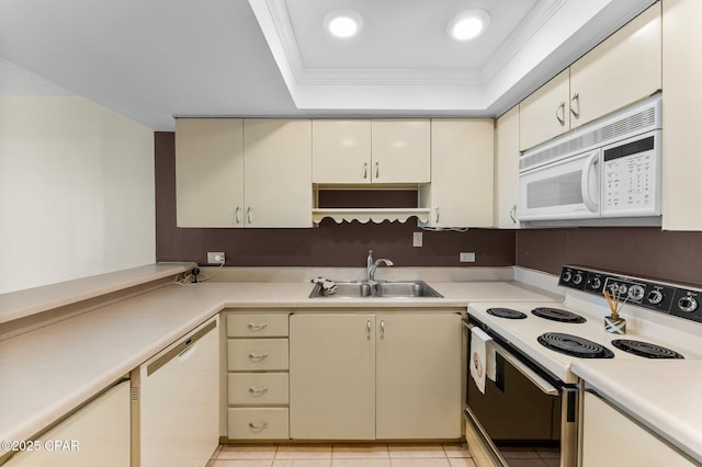 kitchen featuring white appliances, light countertops, a sink, and cream cabinets