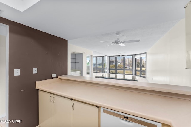 kitchen with a skylight, black electric stovetop, light countertops, white dishwasher, and ceiling fan