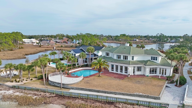 exterior space featuring a fenced in pool, a water view, a patio area, and french doors