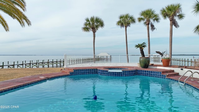 view of swimming pool featuring an in ground hot tub and a water view