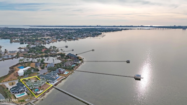 aerial view at dusk featuring a water view