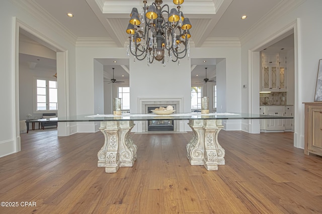 unfurnished dining area featuring coffered ceiling, crown molding, and light hardwood / wood-style floors