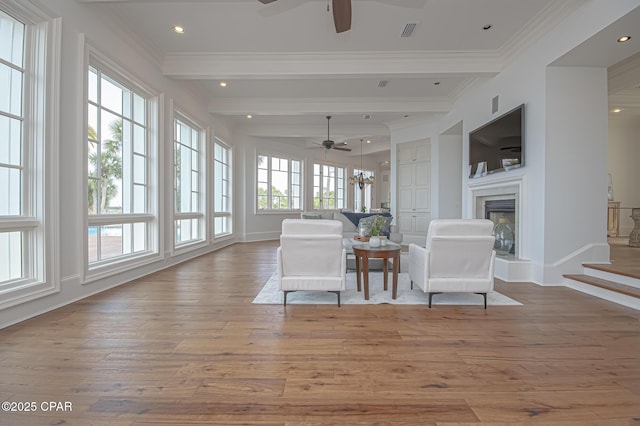 sunroom featuring beam ceiling and ceiling fan