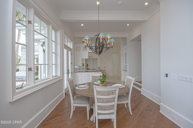 dining area with beamed ceiling, ornamental molding, an inviting chandelier, and light hardwood / wood-style flooring