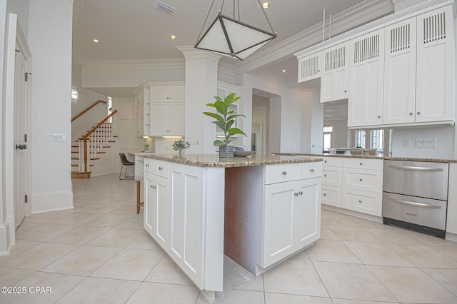 kitchen featuring pendant lighting, light tile patterned floors, light stone countertops, and a center island