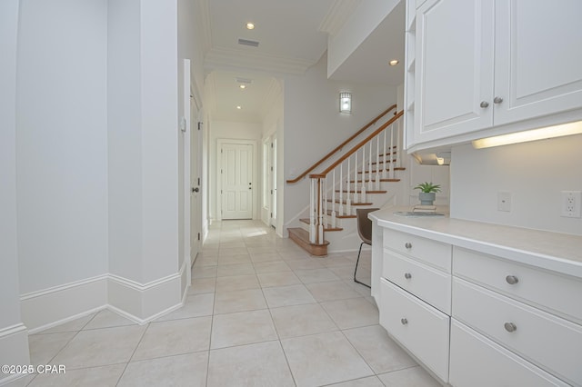 corridor featuring crown molding and light tile patterned floors