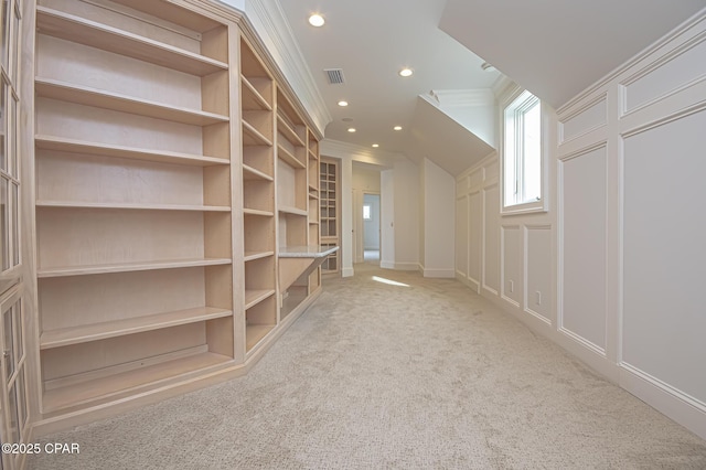 bonus room with built in shelves and light carpet