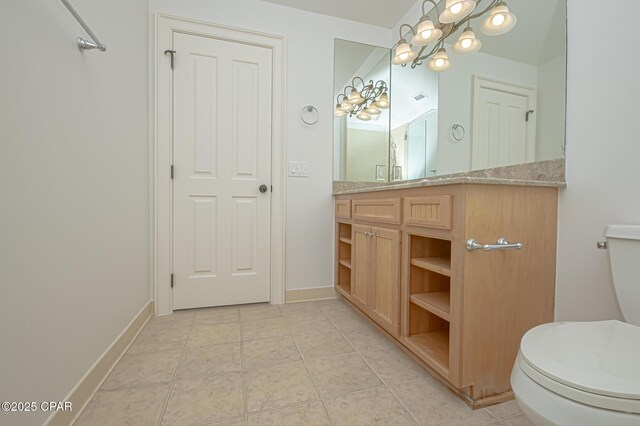 bathroom featuring vanity, tile patterned floors, and toilet