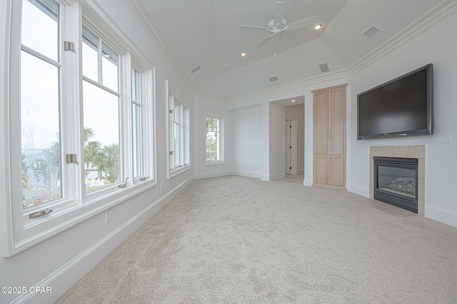 unfurnished living room with lofted ceiling, light colored carpet, ornamental molding, ceiling fan, and a tiled fireplace