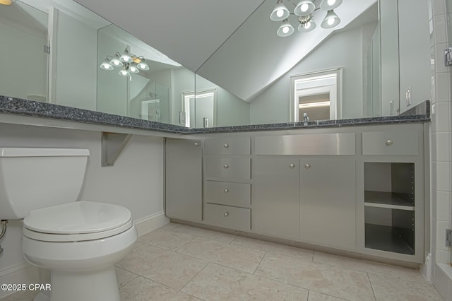 bathroom with vanity, vaulted ceiling, tile patterned floors, and toilet