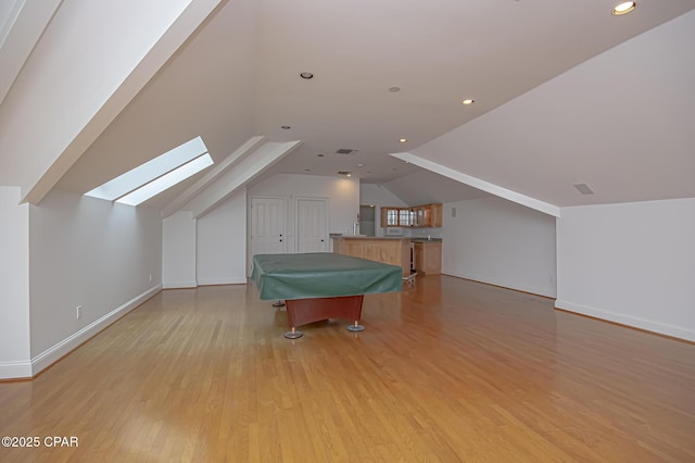 game room with lofted ceiling with skylight, light hardwood / wood-style floors, and billiards