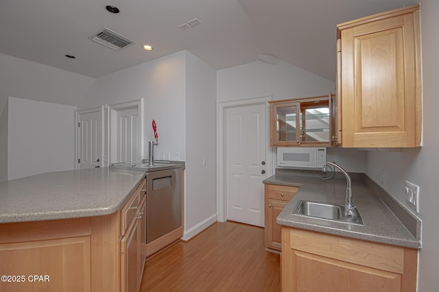 kitchen with light wood-type flooring, vaulted ceiling, sink, and light brown cabinets