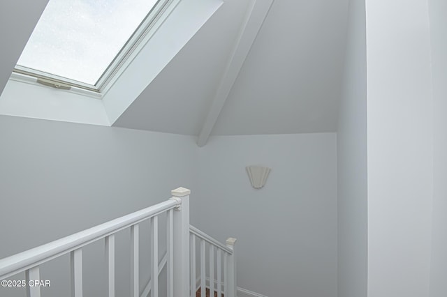 staircase featuring vaulted ceiling with skylight