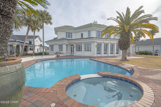 view of pool featuring a patio and an in ground hot tub