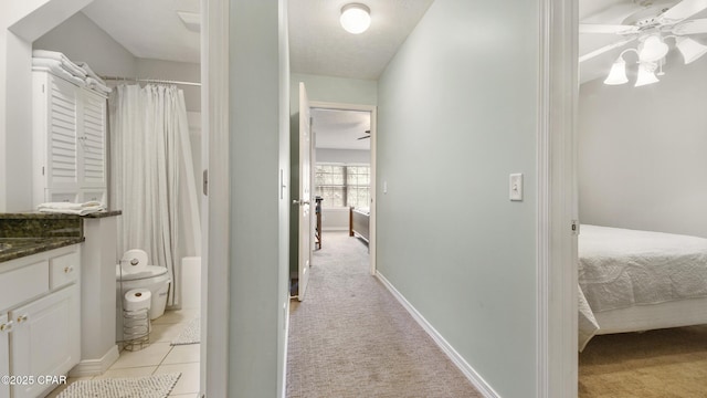 bathroom with tile patterned flooring, vanity, walk in shower, ceiling fan, and toilet