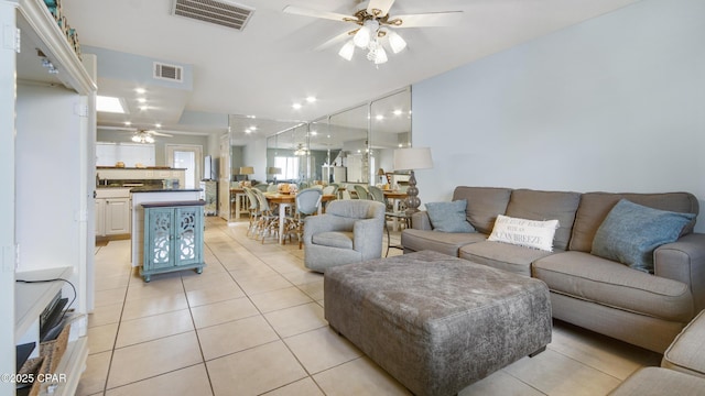 living room featuring light tile patterned floors and ceiling fan