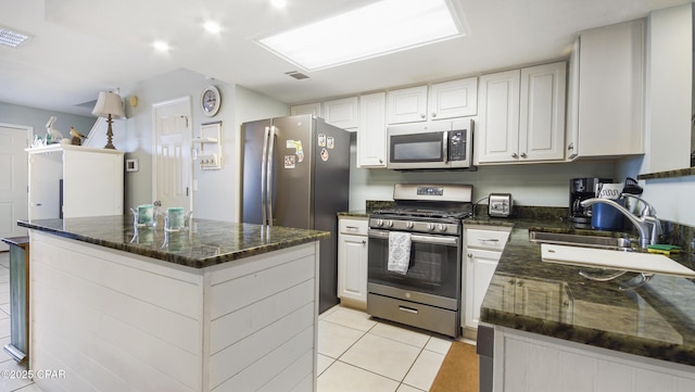 kitchen with a kitchen island, appliances with stainless steel finishes, sink, and white cabinets