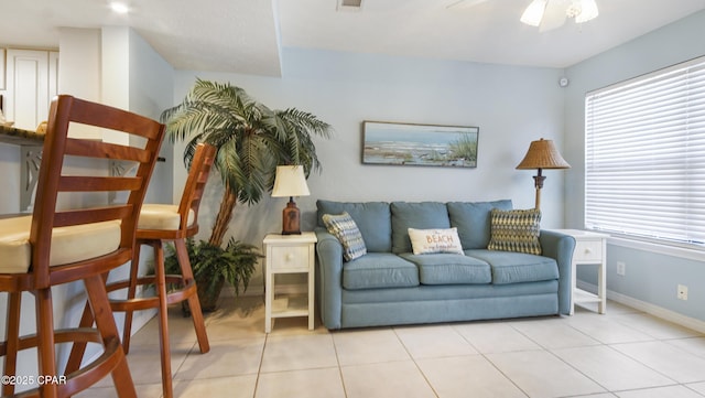 living room featuring a wealth of natural light, ceiling fan, and light tile patterned floors