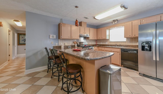 kitchen with light brown cabinets, kitchen peninsula, dark stone counters, and appliances with stainless steel finishes