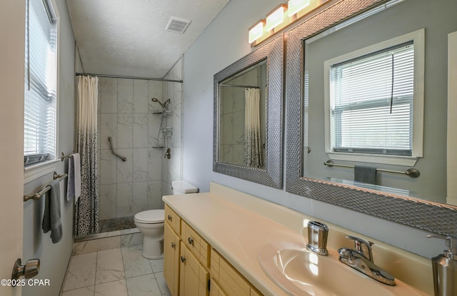 bathroom featuring vanity, toilet, curtained shower, and a textured ceiling