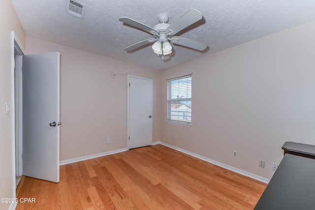 unfurnished bedroom with ceiling fan, light hardwood / wood-style floors, and a textured ceiling