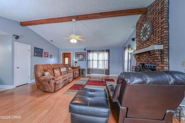 living room with vaulted ceiling with beams, a fireplace, hardwood / wood-style floors, and a textured ceiling