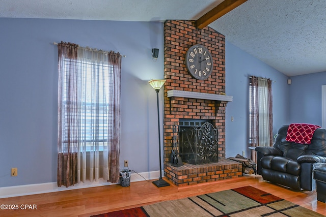 living room with a fireplace, hardwood / wood-style floors, a textured ceiling, and vaulted ceiling with beams