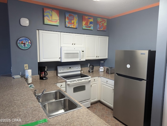 kitchen featuring sink, white cabinets, and white appliances