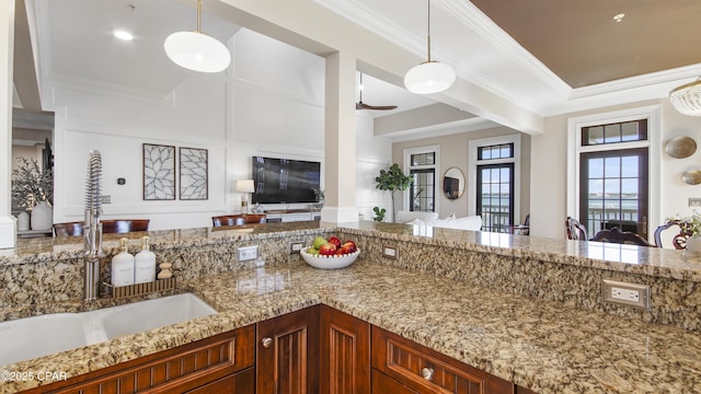 kitchen with hanging light fixtures, ornamental molding, and sink