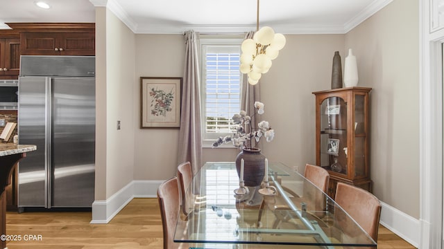 dining area with crown molding, light hardwood / wood-style flooring, and a healthy amount of sunlight