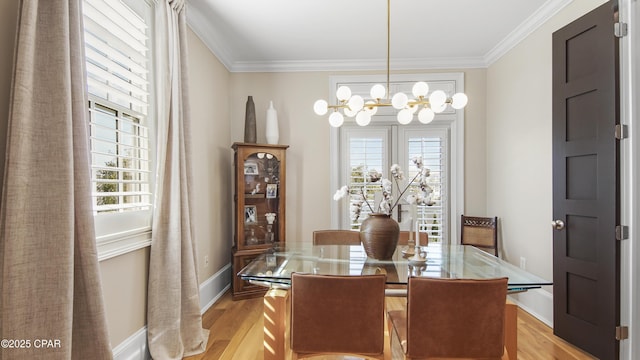 dining room with a notable chandelier, crown molding, and light hardwood / wood-style floors