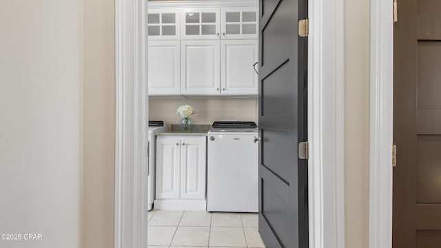 washroom featuring light tile patterned flooring, cabinets, and washing machine and clothes dryer