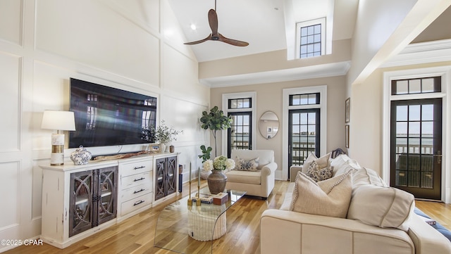 living room with light hardwood / wood-style flooring, high vaulted ceiling, and ceiling fan