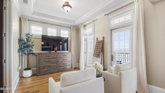 living area featuring ornamental molding, plenty of natural light, and light wood-type flooring