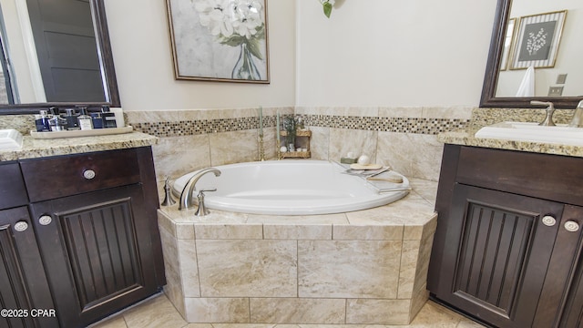 bathroom with vanity, tiled bath, and tile patterned flooring