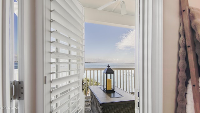 balcony featuring ceiling fan and a water view