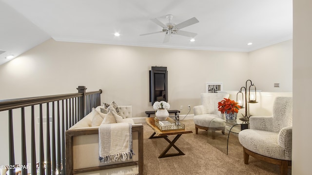 living area featuring ornamental molding, vaulted ceiling, carpet flooring, and ceiling fan