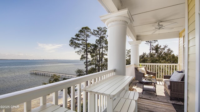 deck with a water view and ceiling fan