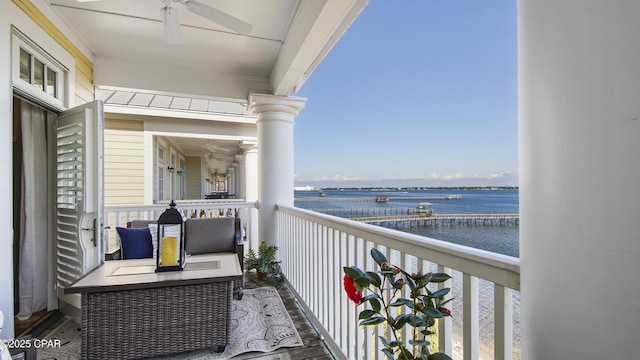 balcony featuring a water view and ceiling fan